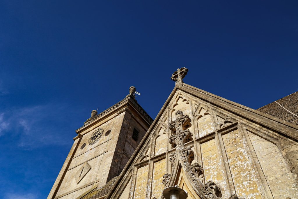 The stone tower of St Cuthbert's against a clear blue sky